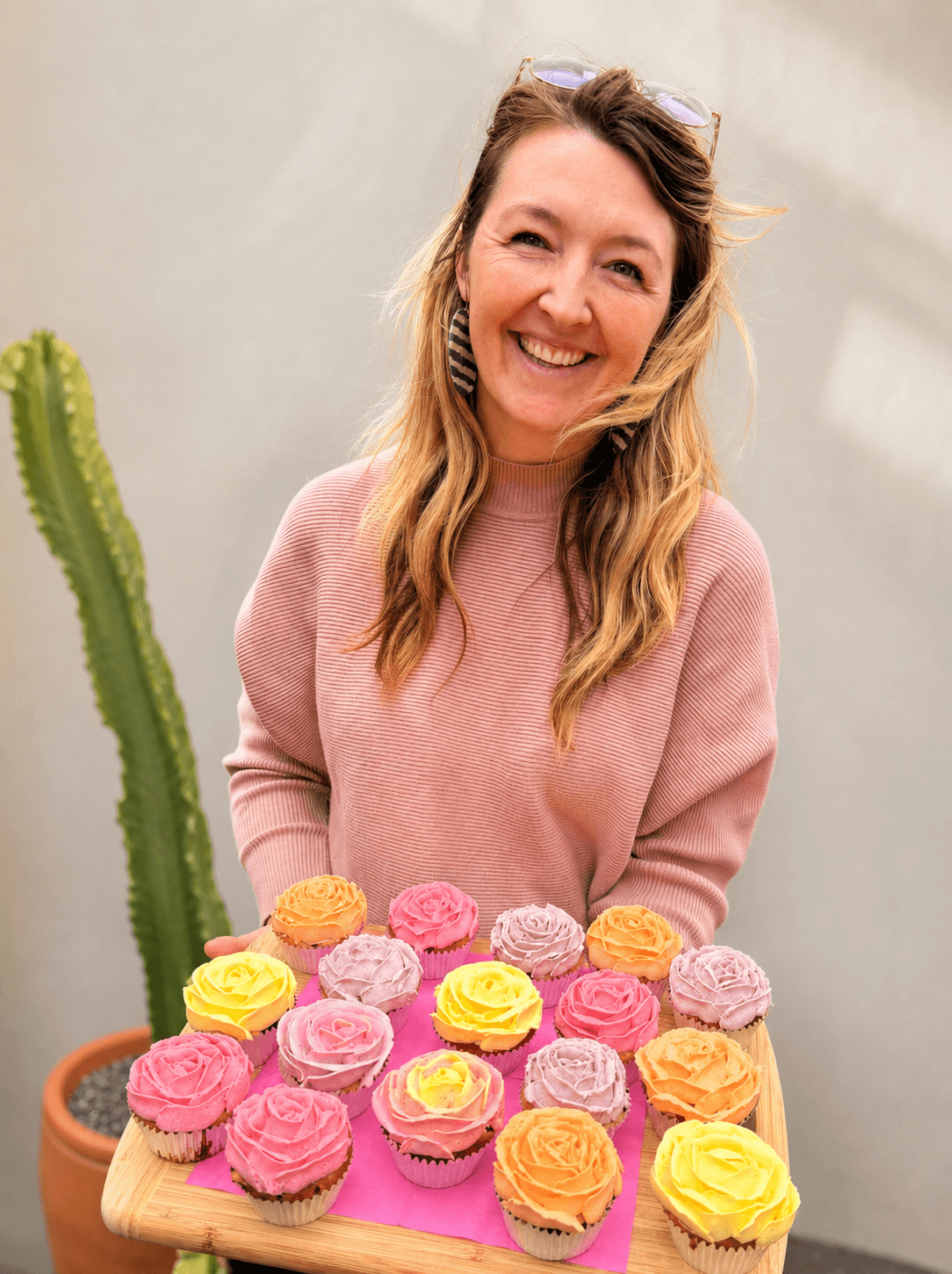 Kara holding a tray of rose cupcakes