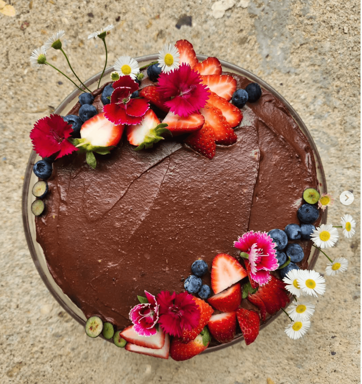 Chocolate cake with fresh flowers and berries